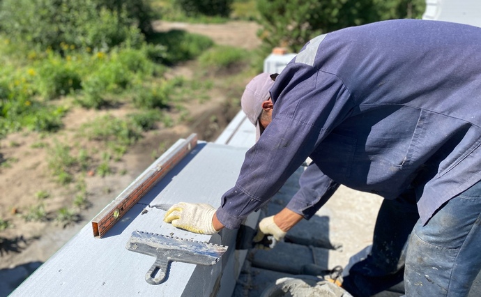 Мастер кладет блок на клей. ГК Урал-Строй